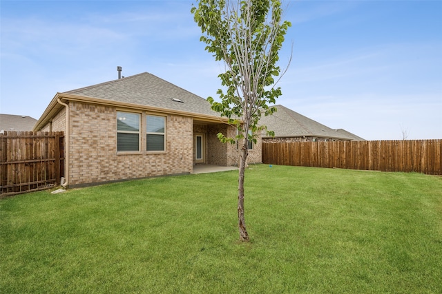 back of house with a patio area and a yard