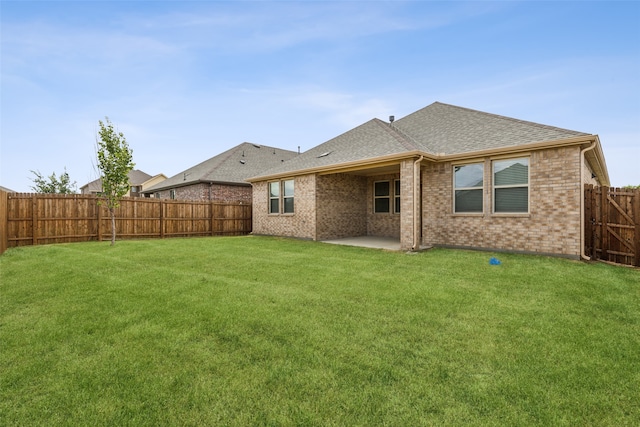 rear view of property with a lawn and a patio