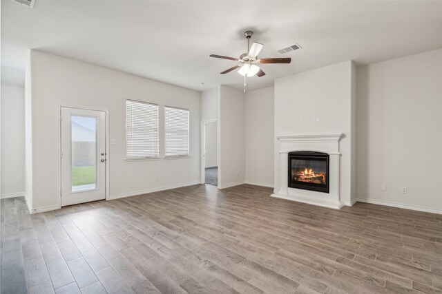 unfurnished living room with ceiling fan and hardwood / wood-style floors