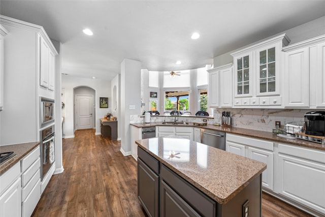 kitchen with stainless steel appliances, white cabinetry, sink, and decorative backsplash