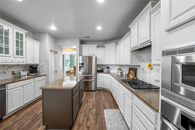 kitchen with white cabinetry, stainless steel appliances, and a kitchen island