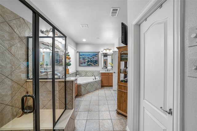 bathroom featuring tile patterned flooring, shower with separate bathtub, and vanity