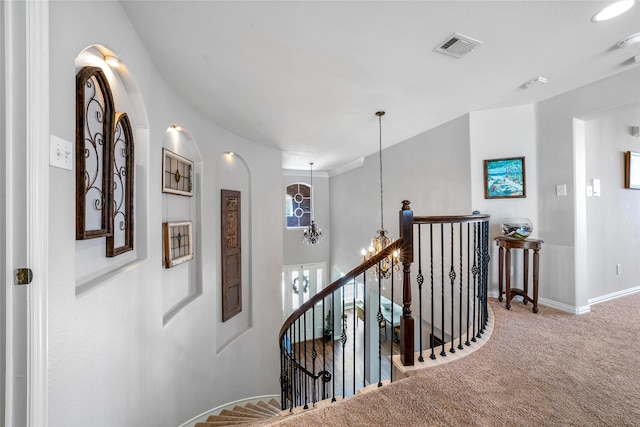 corridor featuring carpet floors and a notable chandelier