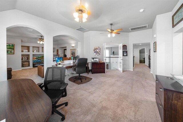 office featuring light carpet, built in shelves, vaulted ceiling, and ceiling fan