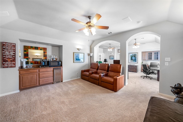 carpeted living room featuring ceiling fan and vaulted ceiling