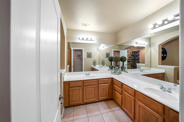 bathroom featuring vanity, tile patterned floors, and a textured ceiling