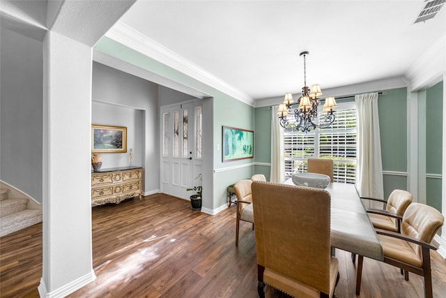 dining space with crown molding, dark wood-type flooring, and a chandelier