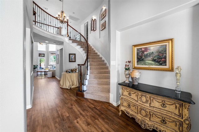 foyer entrance with a towering ceiling, a chandelier, and dark hardwood / wood-style flooring