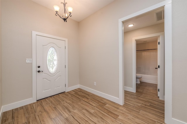 entryway with a chandelier and light hardwood / wood-style flooring