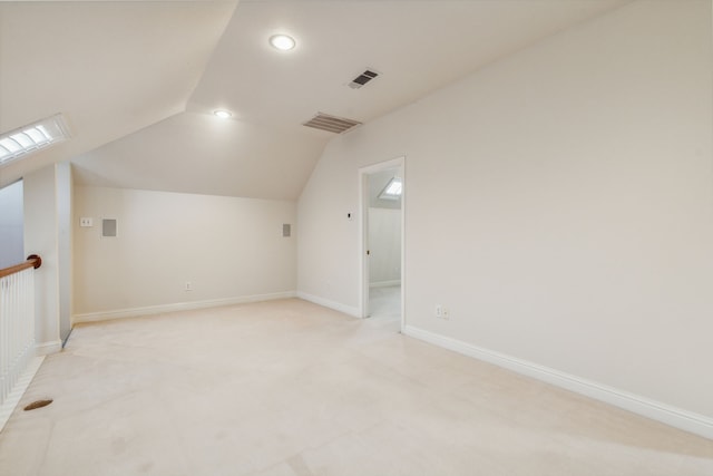 bonus room with light colored carpet and lofted ceiling