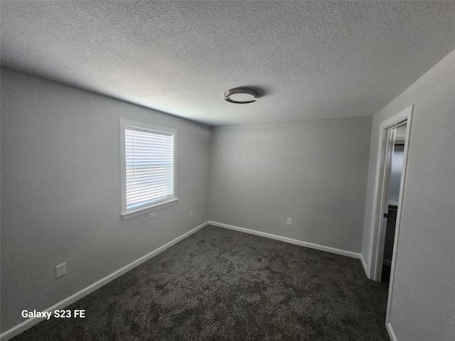 5280 Atwell Ln, Denton, TX 76208 - spare room featuring dark carpet, baseboards, and a textured ceiling