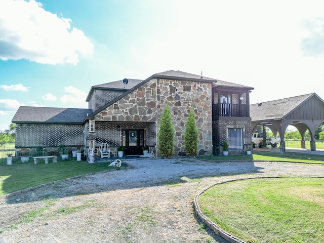 back of property with a balcony and a lawn