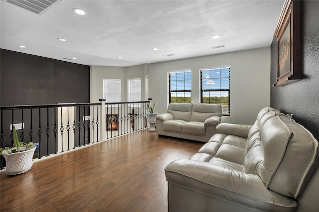 living room with dark wood-type flooring and a textured ceiling