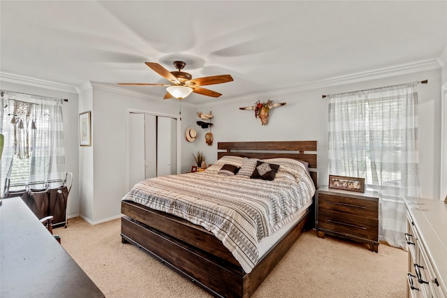 bedroom featuring ornamental molding, light carpet, a closet, and ceiling fan