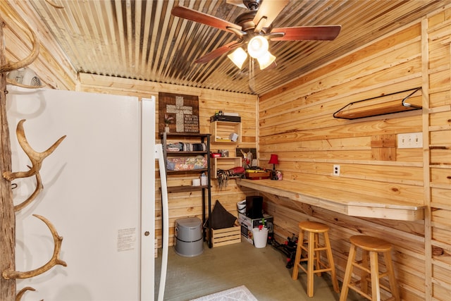 home office featuring wood walls, wooden ceiling, and ceiling fan