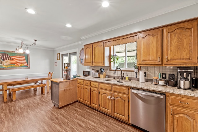 kitchen with a healthy amount of sunlight, hardwood / wood-style floors, sink, dishwasher, and backsplash