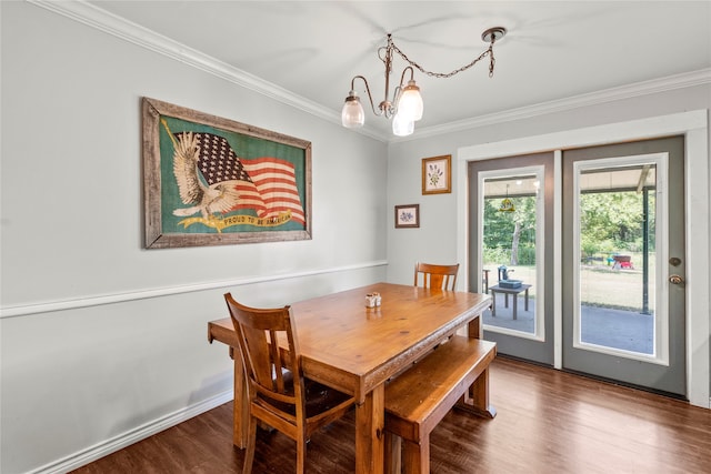 dining space featuring dark hardwood / wood-style flooring, a chandelier, and ornamental molding