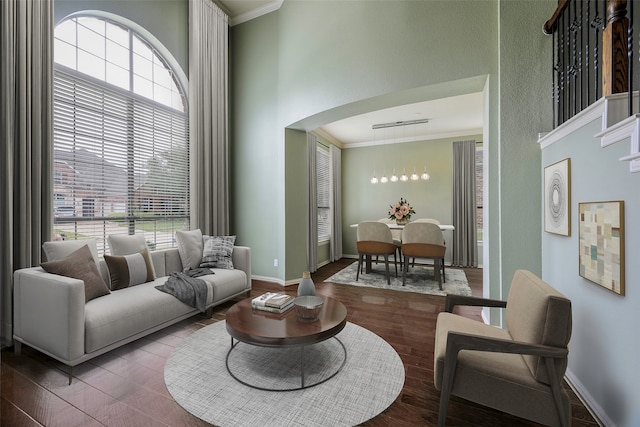 living room featuring crown molding, a towering ceiling, and dark hardwood / wood-style floors