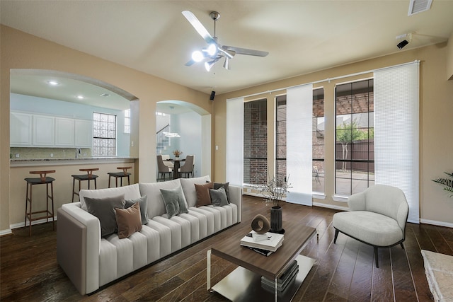 living room with ceiling fan and dark hardwood / wood-style floors