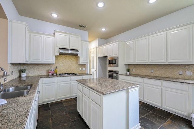 kitchen with stainless steel appliances, sink, a center island, white cabinetry, and range hood