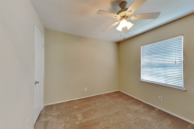 spare room with ceiling fan and light colored carpet