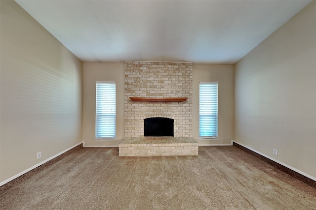 unfurnished living room with a brick fireplace and carpet flooring