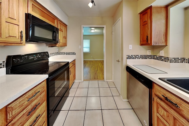 kitchen featuring light tile patterned flooring, rail lighting, and black appliances