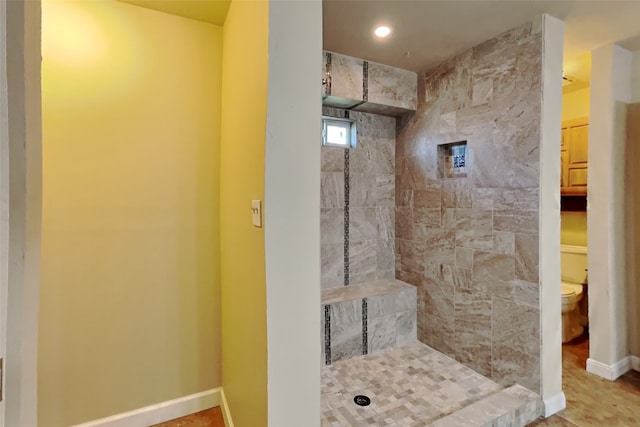 bathroom with toilet and a tile shower