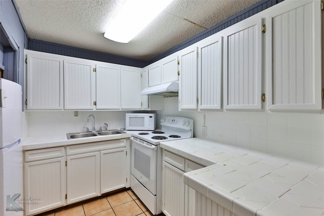 kitchen featuring light tile patterned flooring, white cabinetry, white appliances, tile countertops, and sink