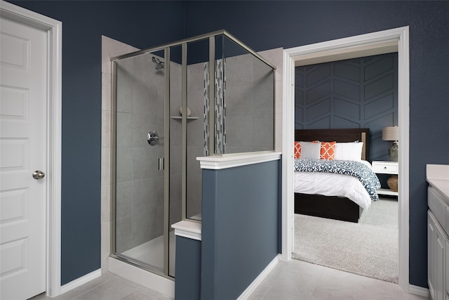 bathroom with tile patterned flooring, a shower with door, and vanity