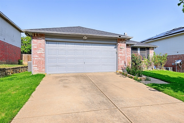 view of front of property with a front lawn, solar panels, central AC, and a garage