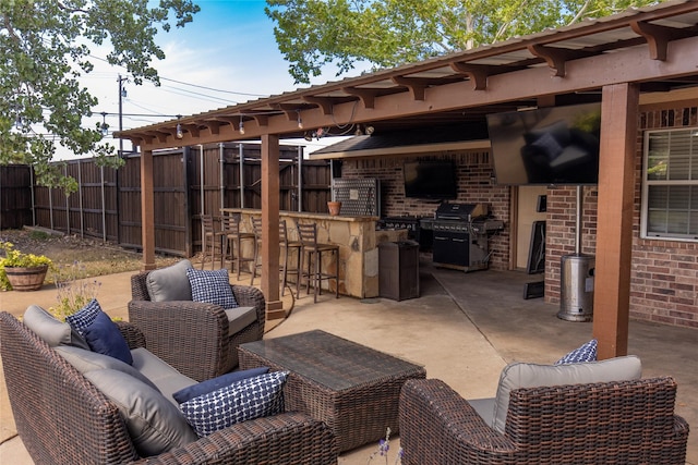 view of patio / terrace with an outdoor living space, fence, grilling area, and outdoor dry bar