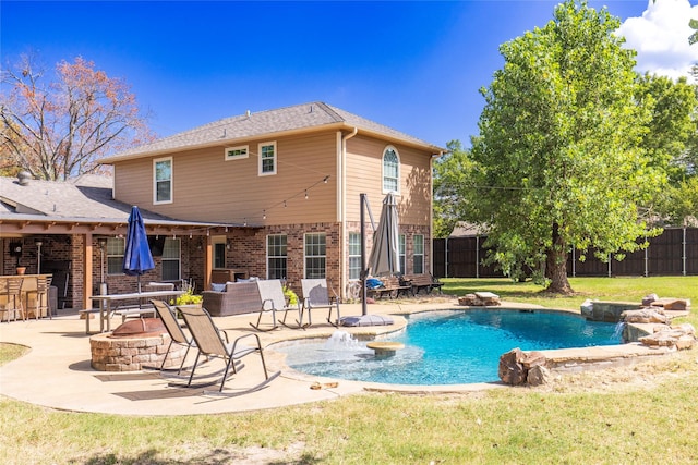 view of swimming pool with a yard, a fire pit, fence, and a patio