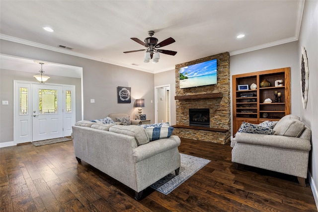 living area with dark wood-type flooring, a fireplace, visible vents, and crown molding