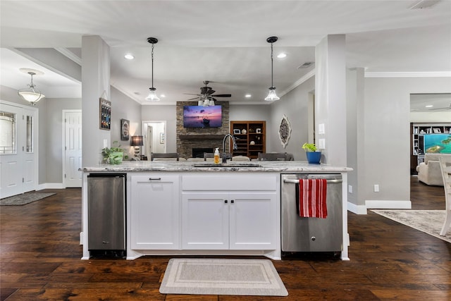 kitchen featuring baseboards, a ceiling fan, a sink, open floor plan, and dark wood-style floors