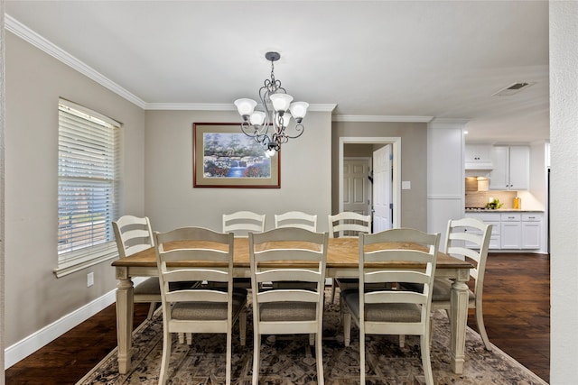 dining space with dark wood-type flooring, crown molding, and an inviting chandelier