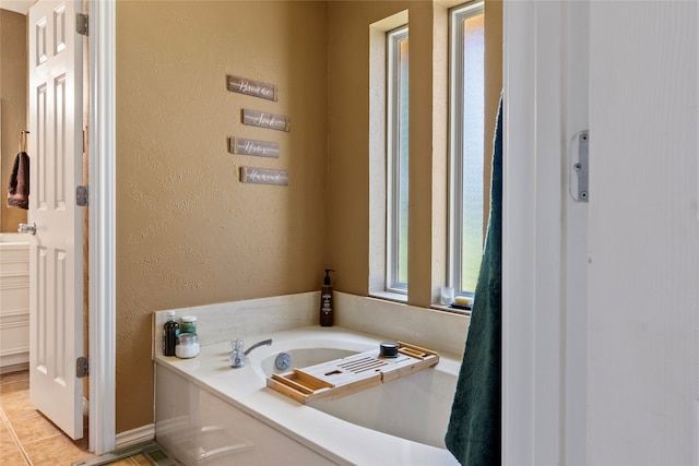 bathroom with a washtub and tile patterned floors