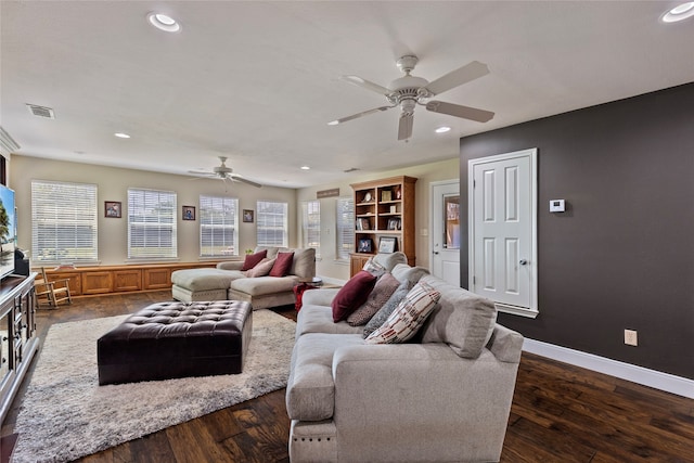 living room featuring ceiling fan, dark wood-type flooring, and plenty of natural light