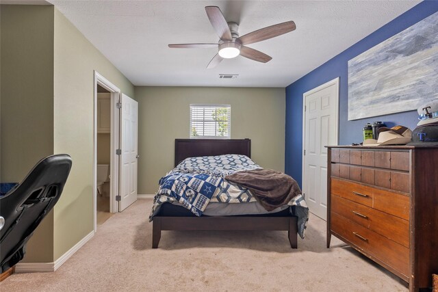 bedroom with carpet flooring, a textured ceiling, baseboards, visible vents, and ceiling fan