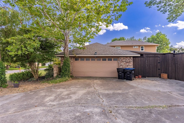view of property exterior featuring a shingled roof, an attached garage, brick siding, and concrete driveway