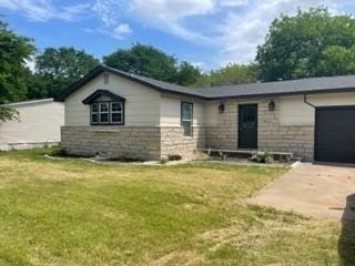 ranch-style house with a garage and a front lawn