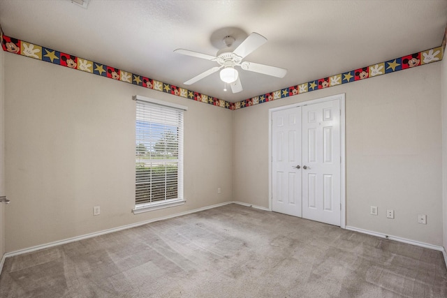 unfurnished bedroom featuring ceiling fan, a closet, and light carpet