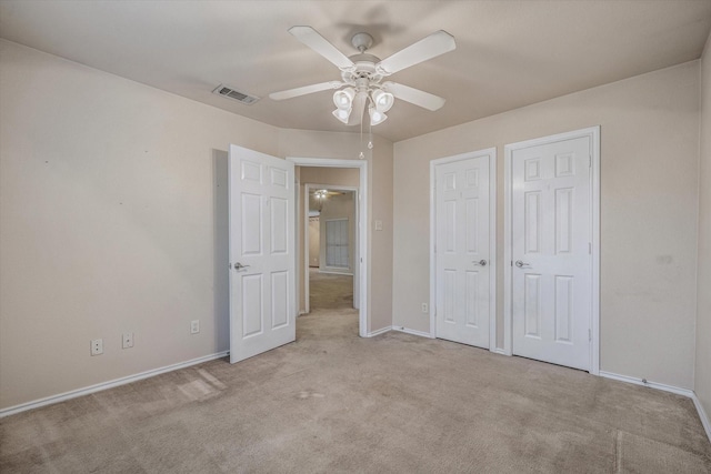 unfurnished bedroom with ceiling fan and light colored carpet