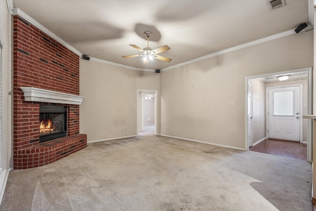 unfurnished living room featuring ceiling fan, a fireplace, crown molding, and carpet flooring