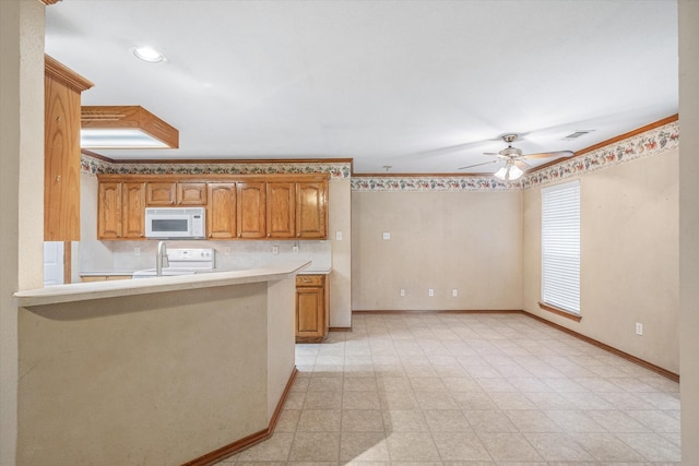 kitchen featuring ceiling fan, kitchen peninsula, and white appliances