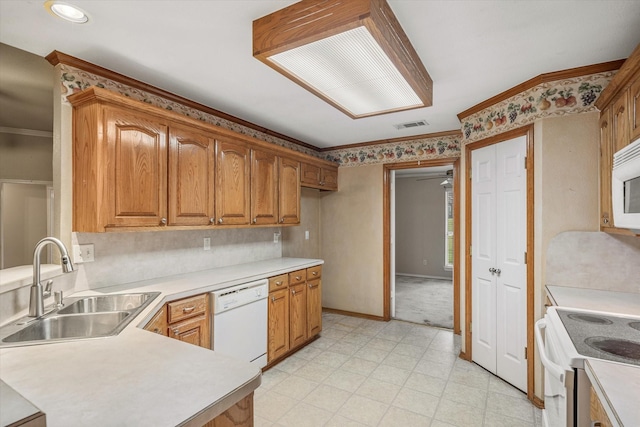 kitchen featuring sink, white appliances, and ornamental molding