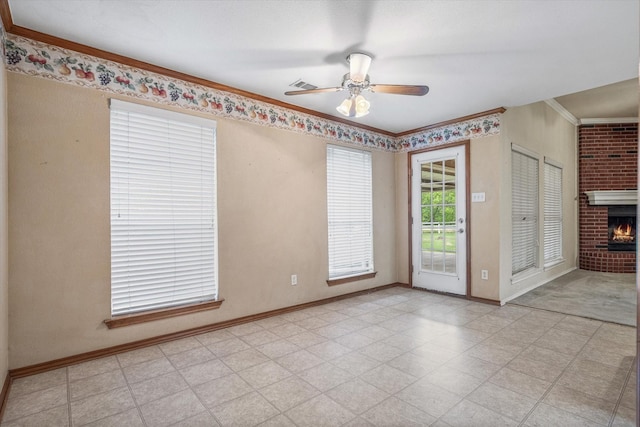 empty room with ceiling fan, a fireplace, and crown molding