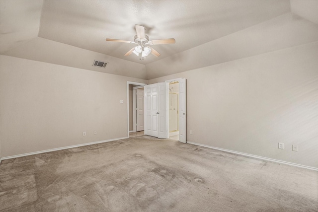 carpeted spare room featuring ceiling fan, a tray ceiling, and lofted ceiling