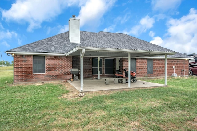 back of property with a lawn and a patio