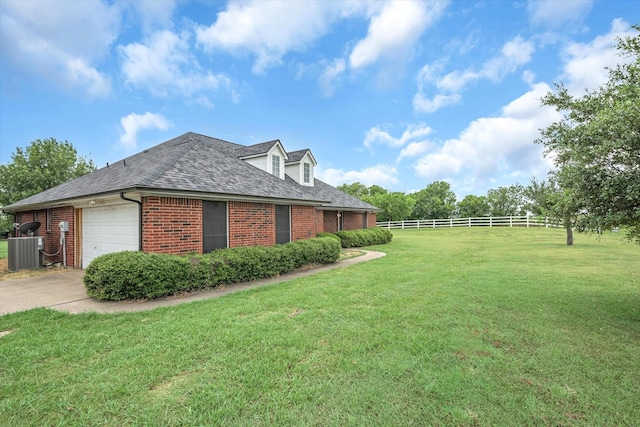 view of side of home with a garage, central AC unit, and a lawn